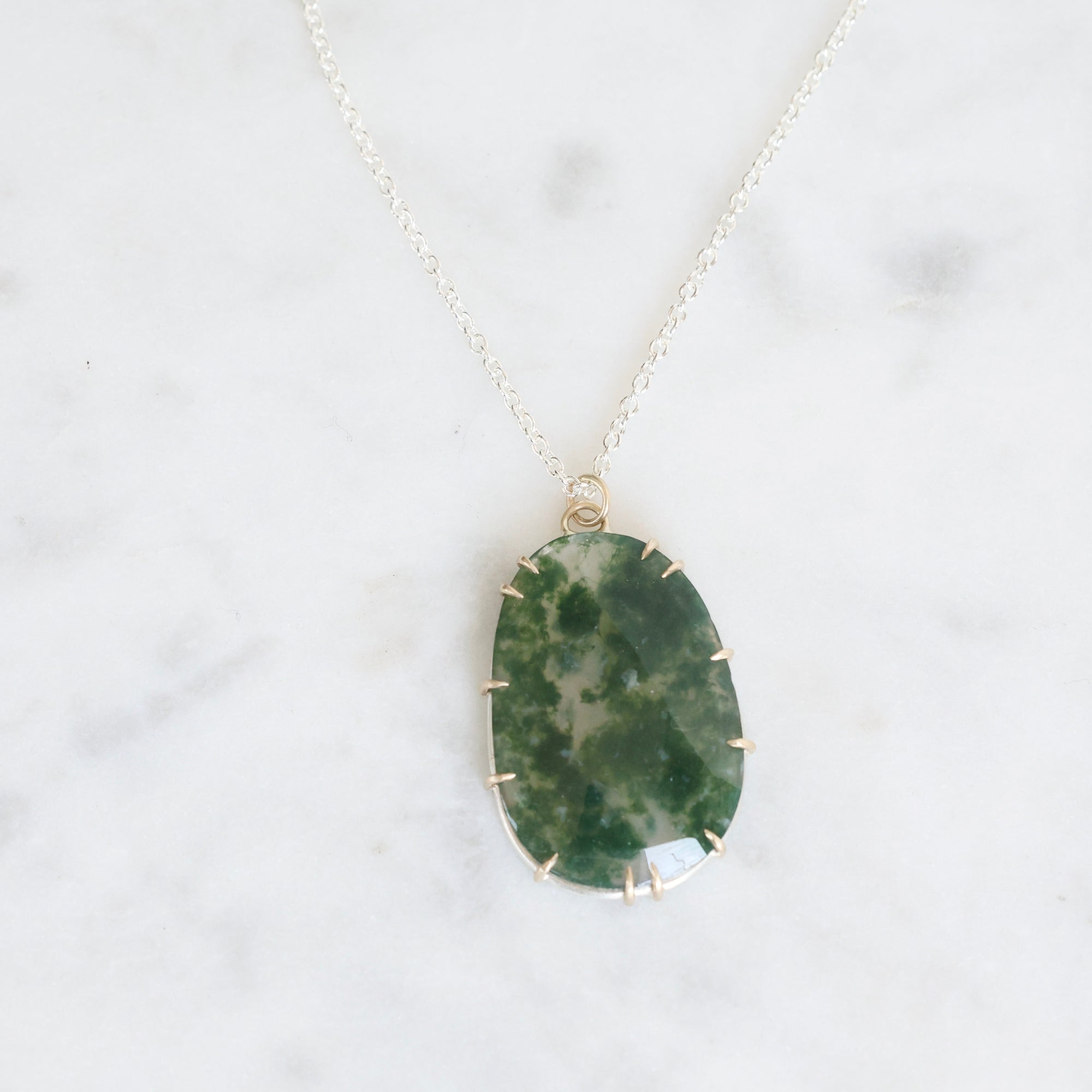 Necklace with a green stone pendant on a white background