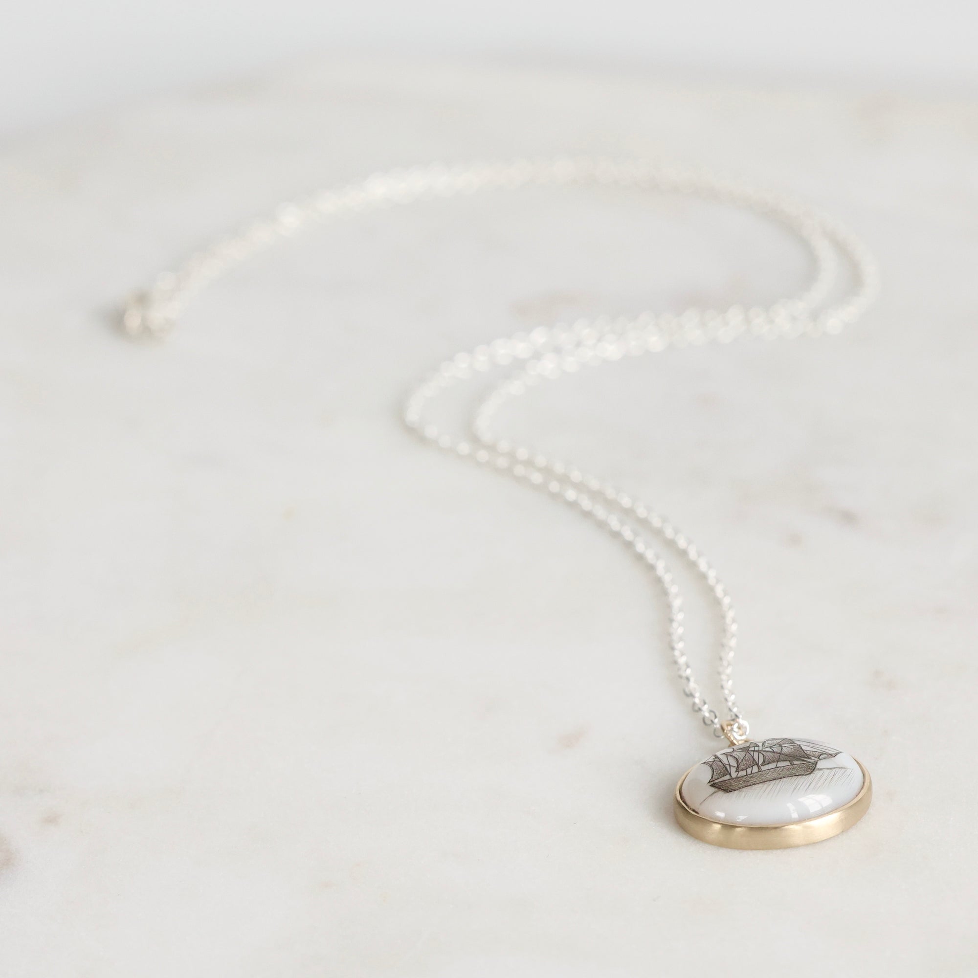 Pearl necklace with a pendant on a light gray background