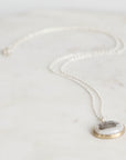 Pearl necklace with a pendant on a light gray background