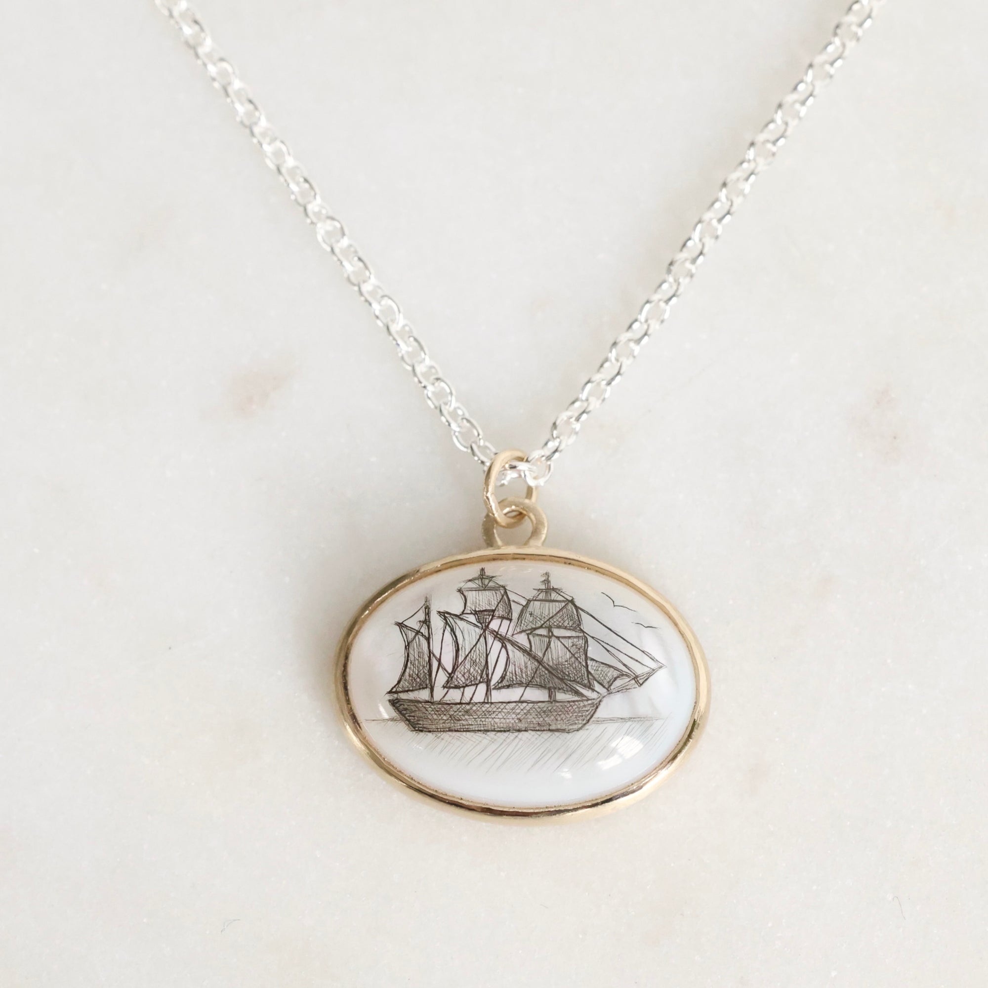 Necklace with a pendant featuring a ship design on a light background