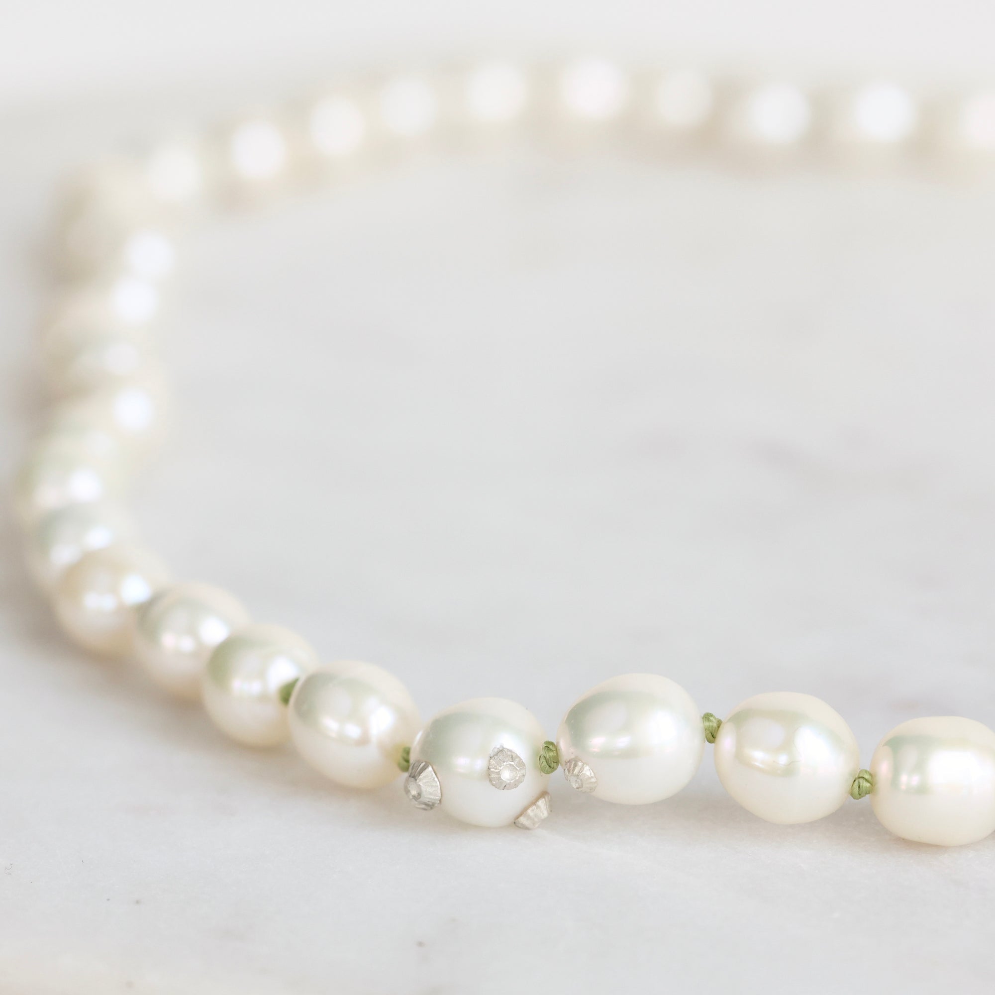 Pearl necklace on a light gray background