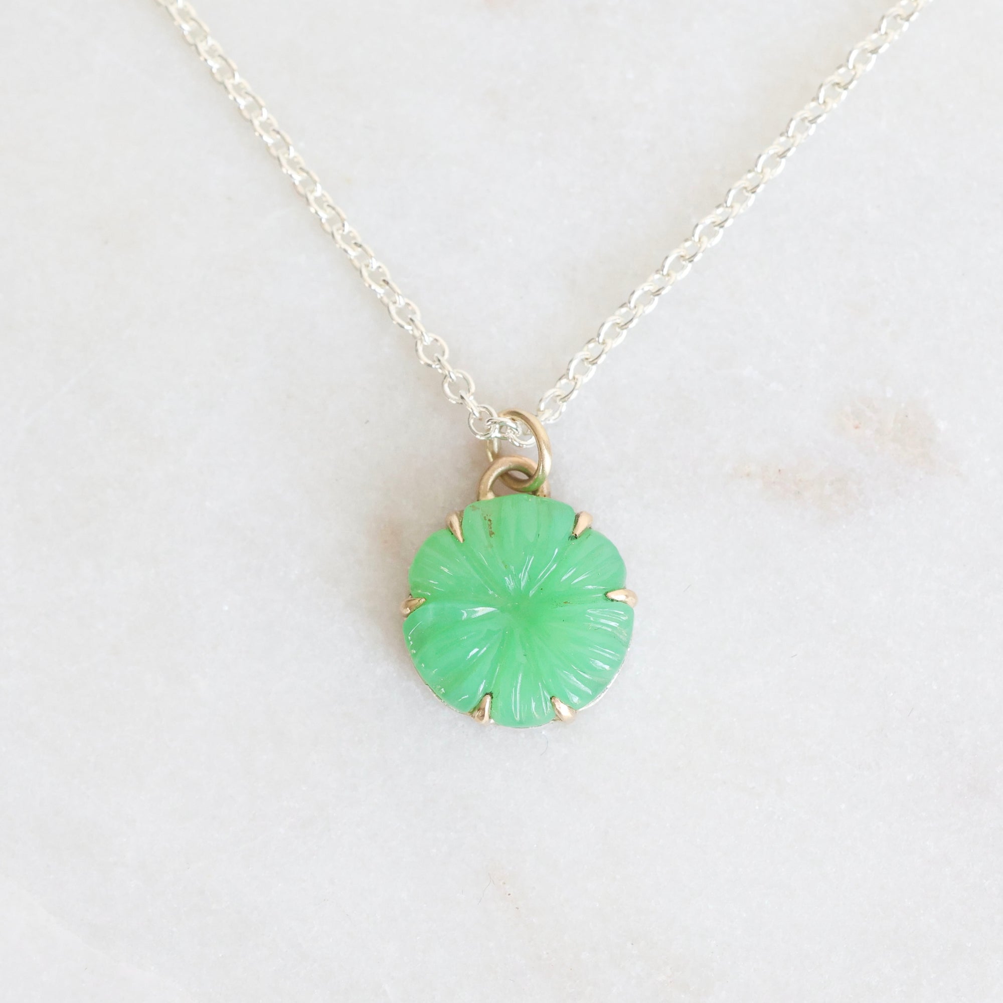 Necklace with a green pendant on a light gray background