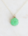Necklace with a green pendant on a light gray background