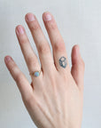 Hand with a ring and a small tattoo on a plain background