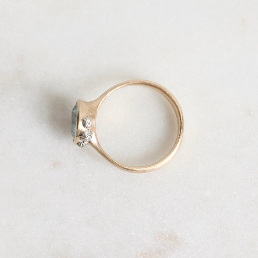Gold ring with a gemstone on a light gray background