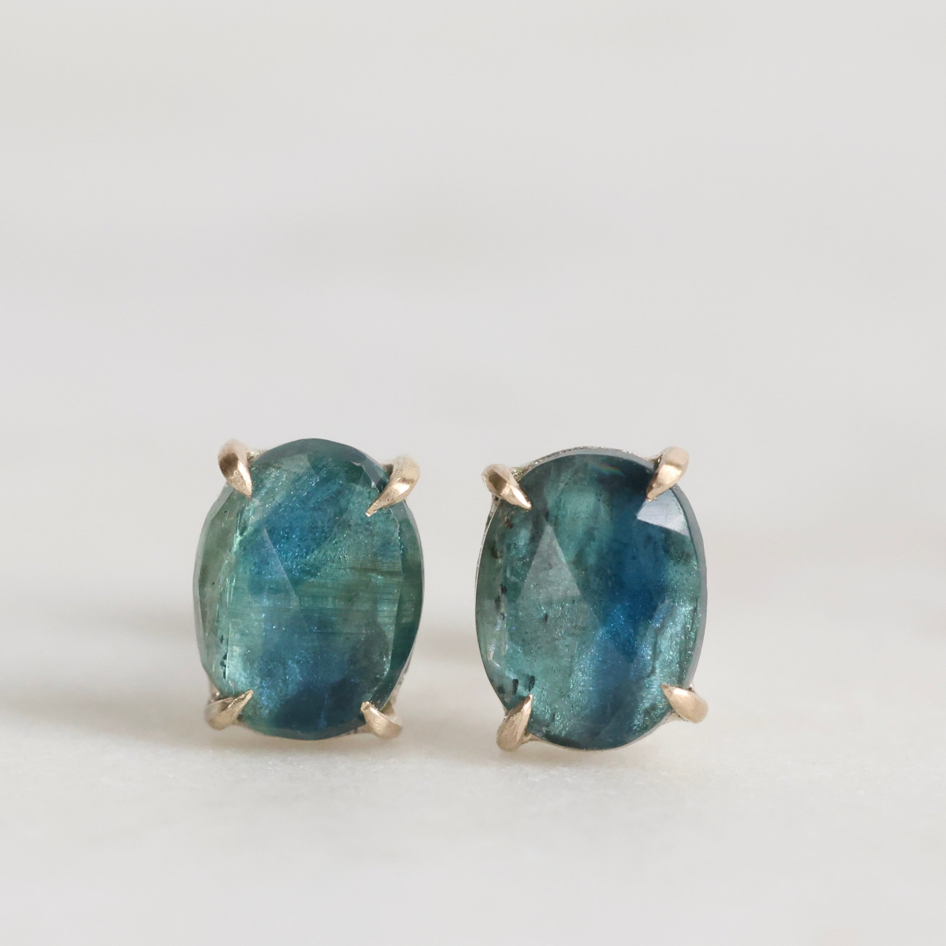 Pair of blue gemstone earrings on a light gray background