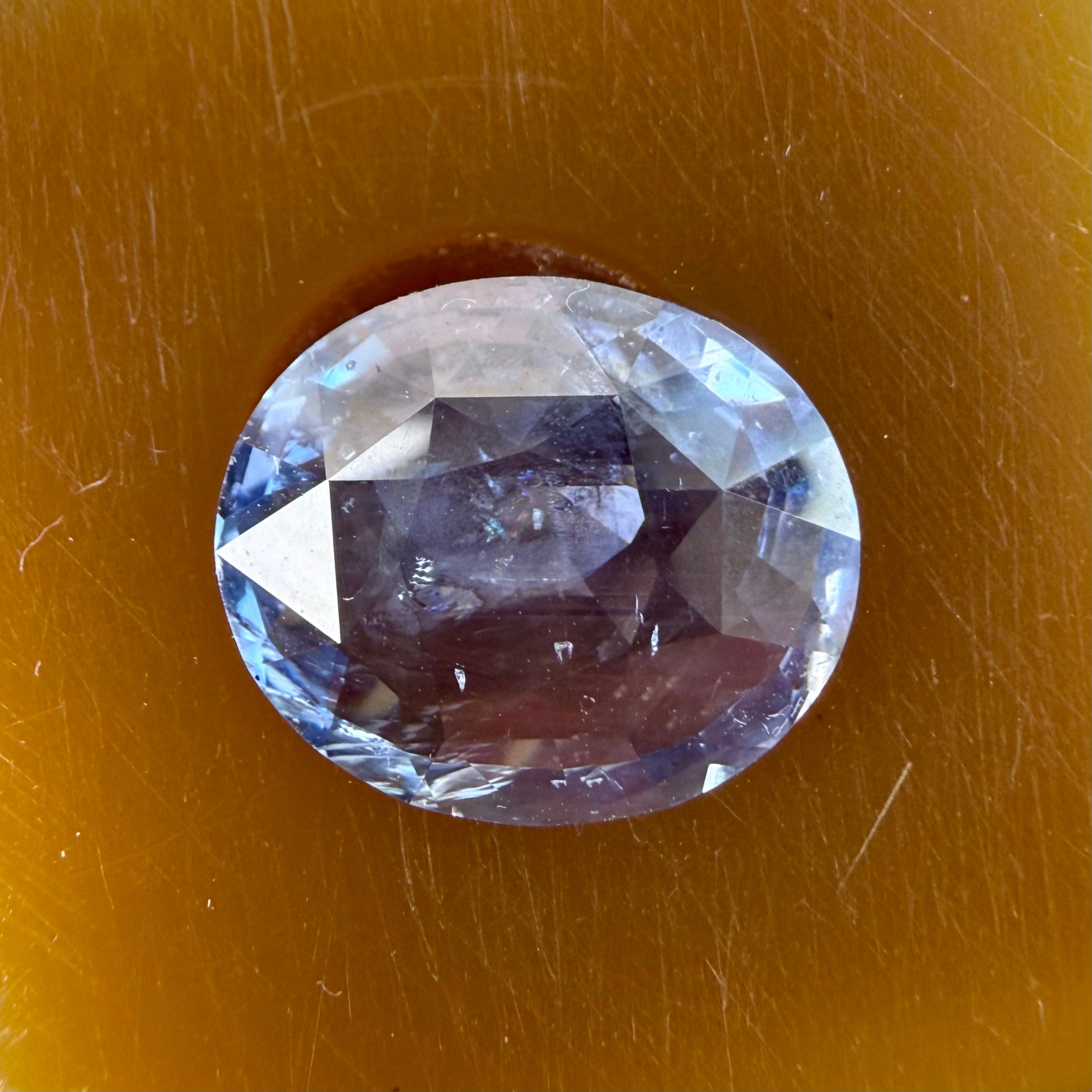 Faceted gemstone on a brown background