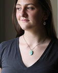 Woman wearing a necklace with a pendant indoors