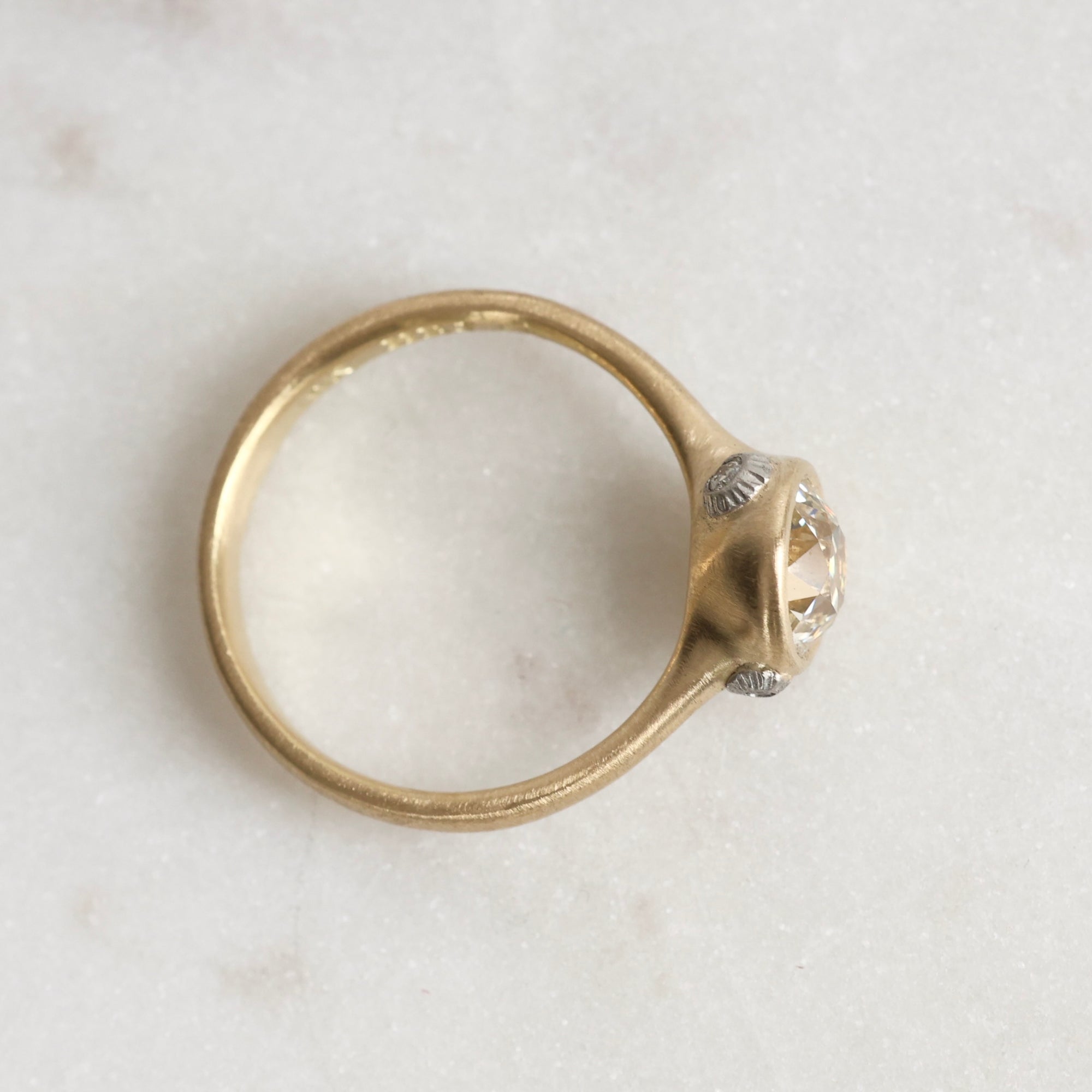 Gold ring with diamond and platinum barnacles on a white background 