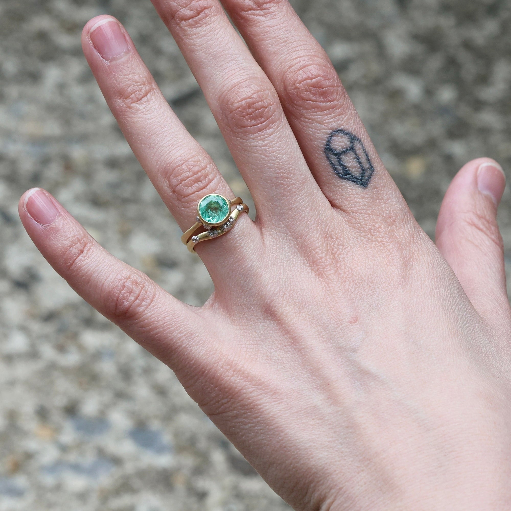 cured barnacle band with green gemstone ring 