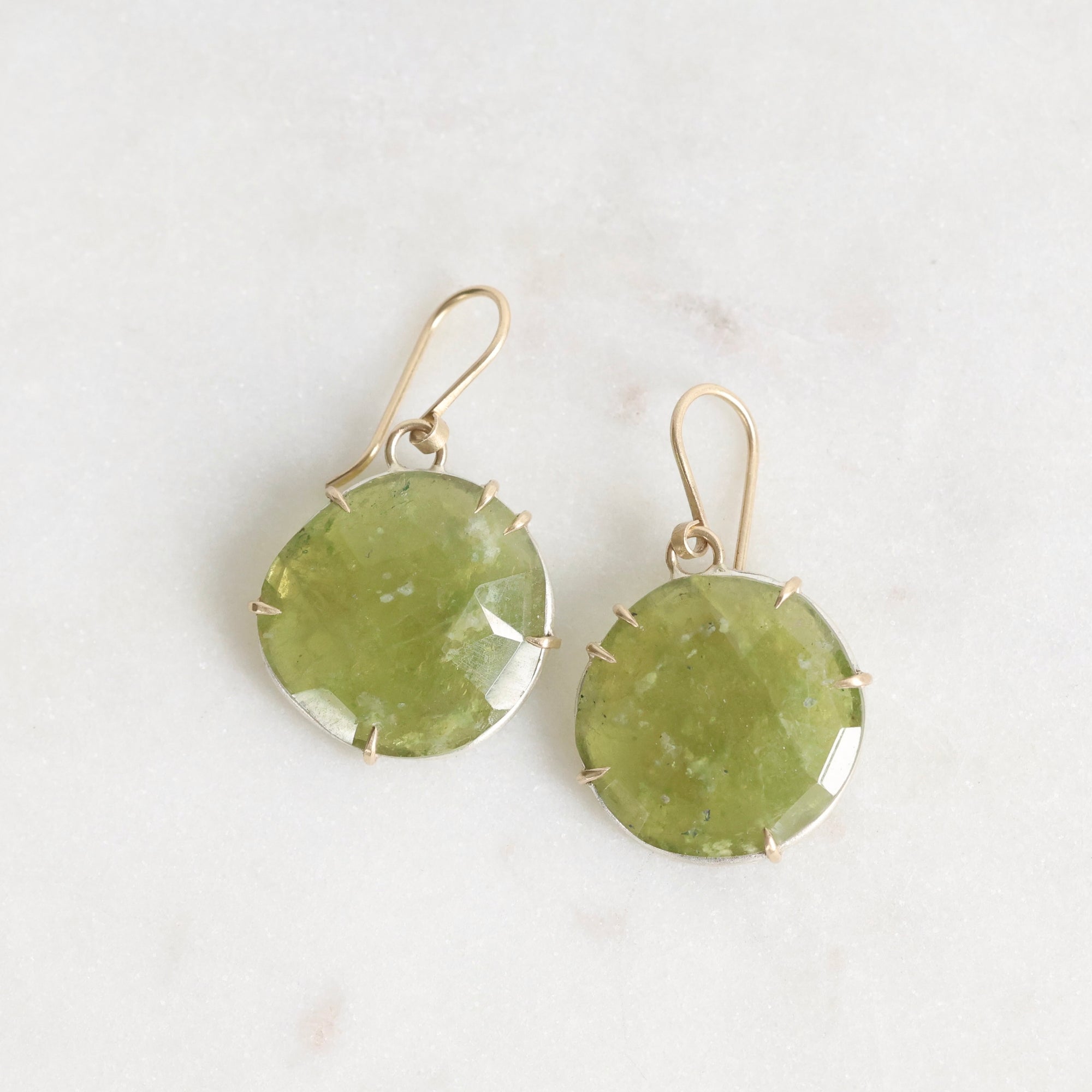 Pair of green stone earrings on a light background