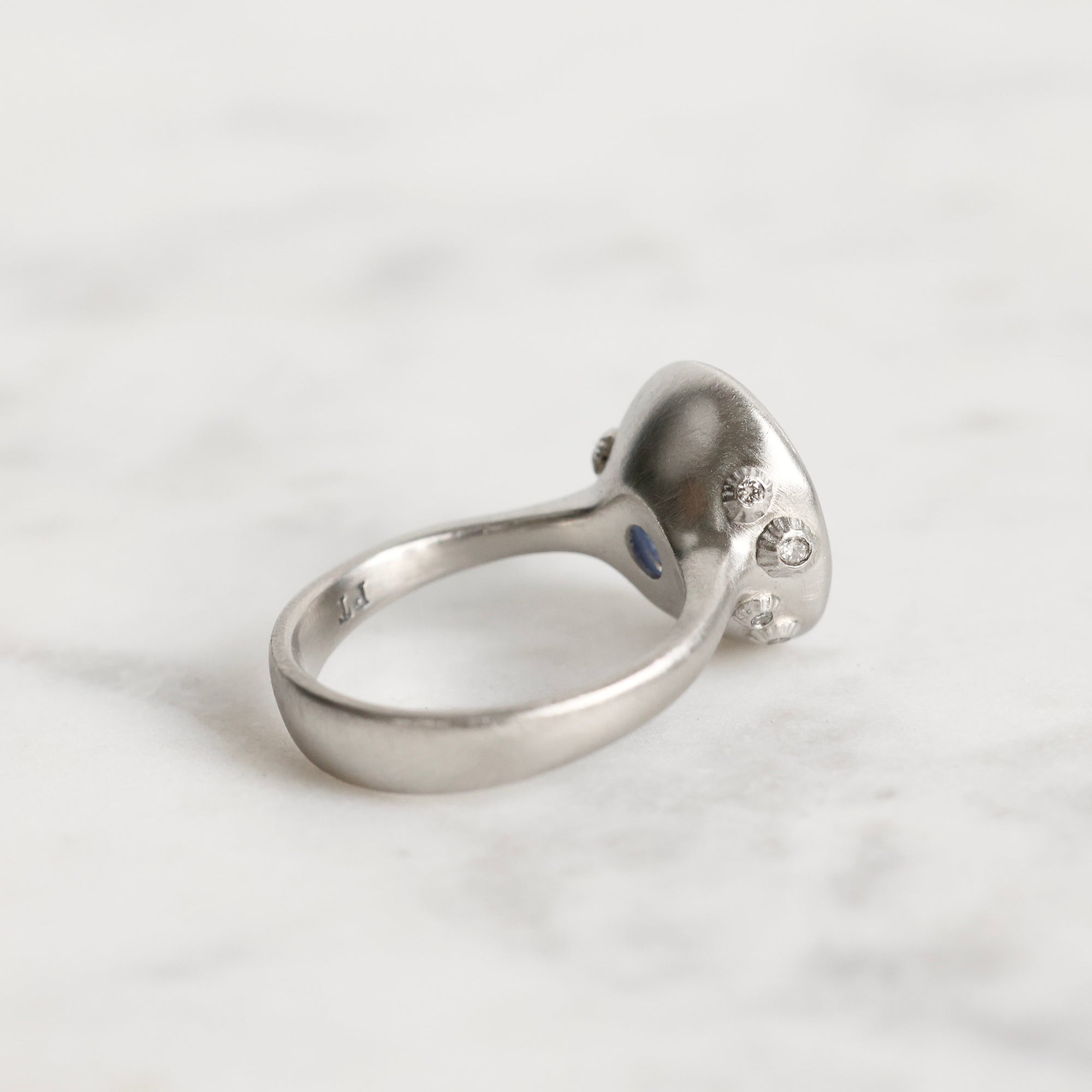 Silver ring with gemstones on a light gray background