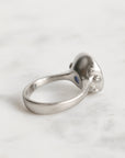 Silver ring with gemstones on a light gray background