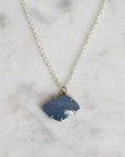 Necklace with a blue pendant on a marble surface