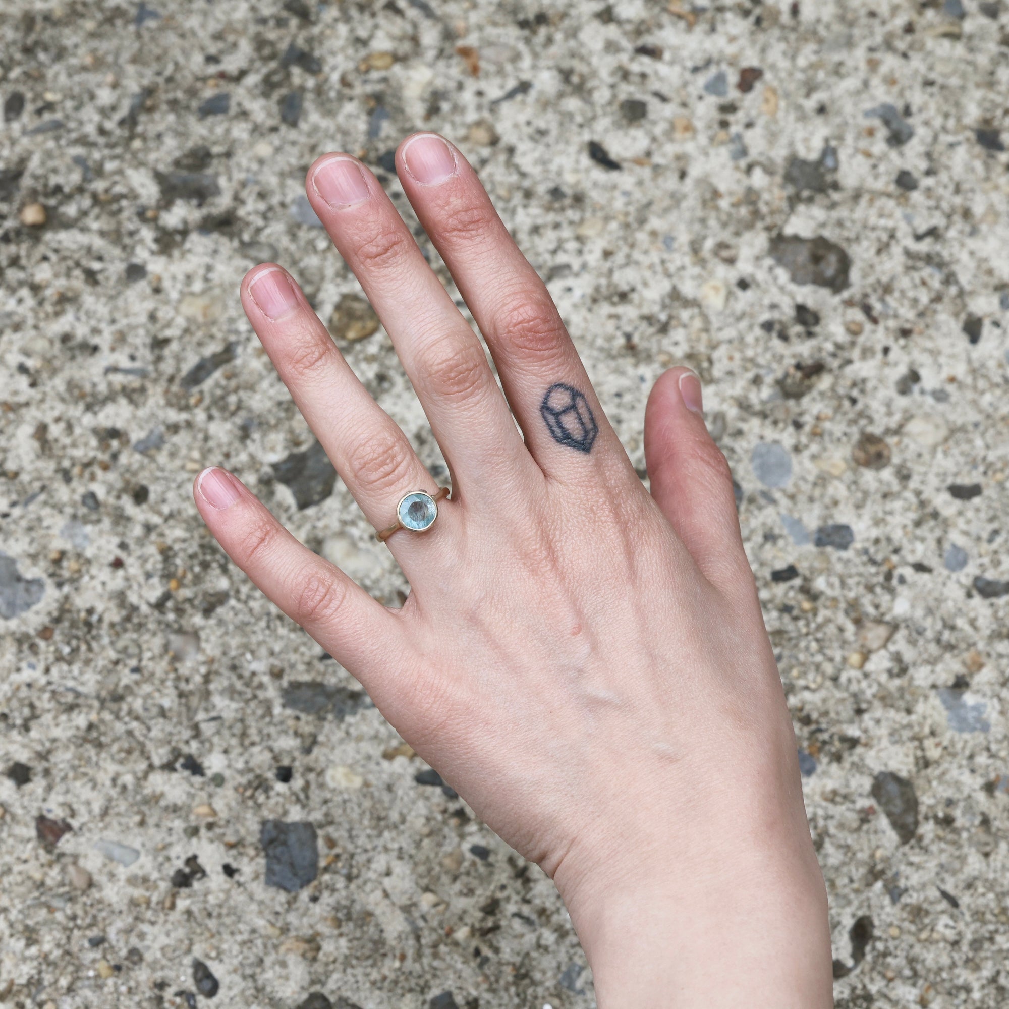 Gold aquamarine ring on hand