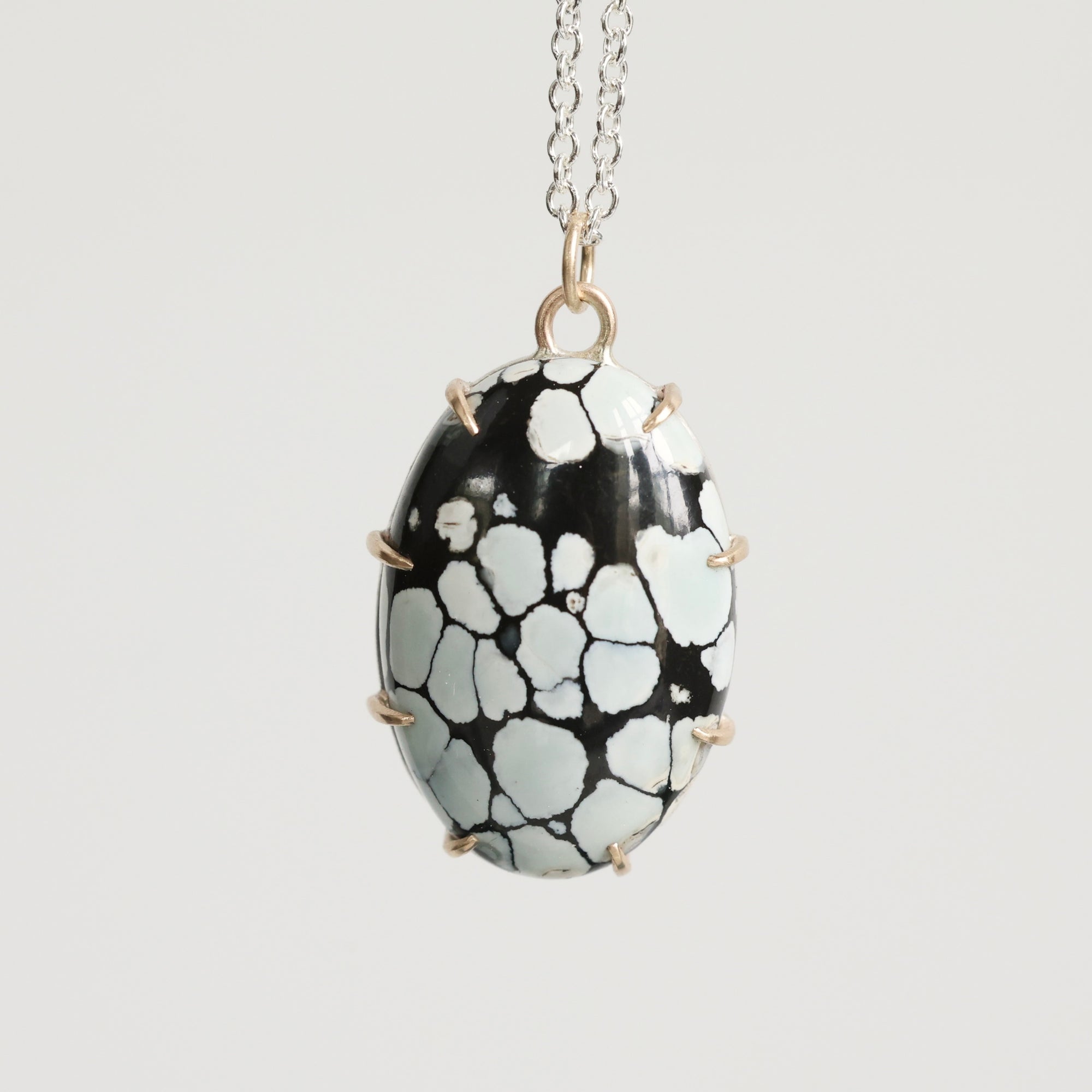 Necklace with a black and white patterned pendant on a light gray background