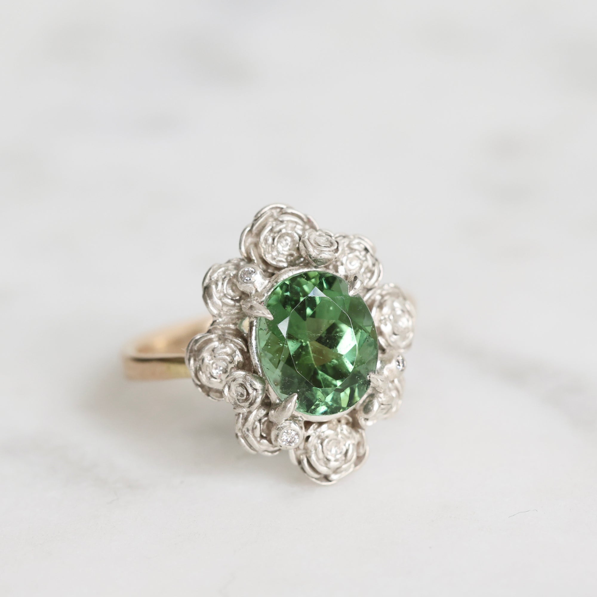 Silver ring with a green gemstone on a white background