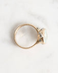 Gold ring with a large, faceted aquamarine stone on a light background