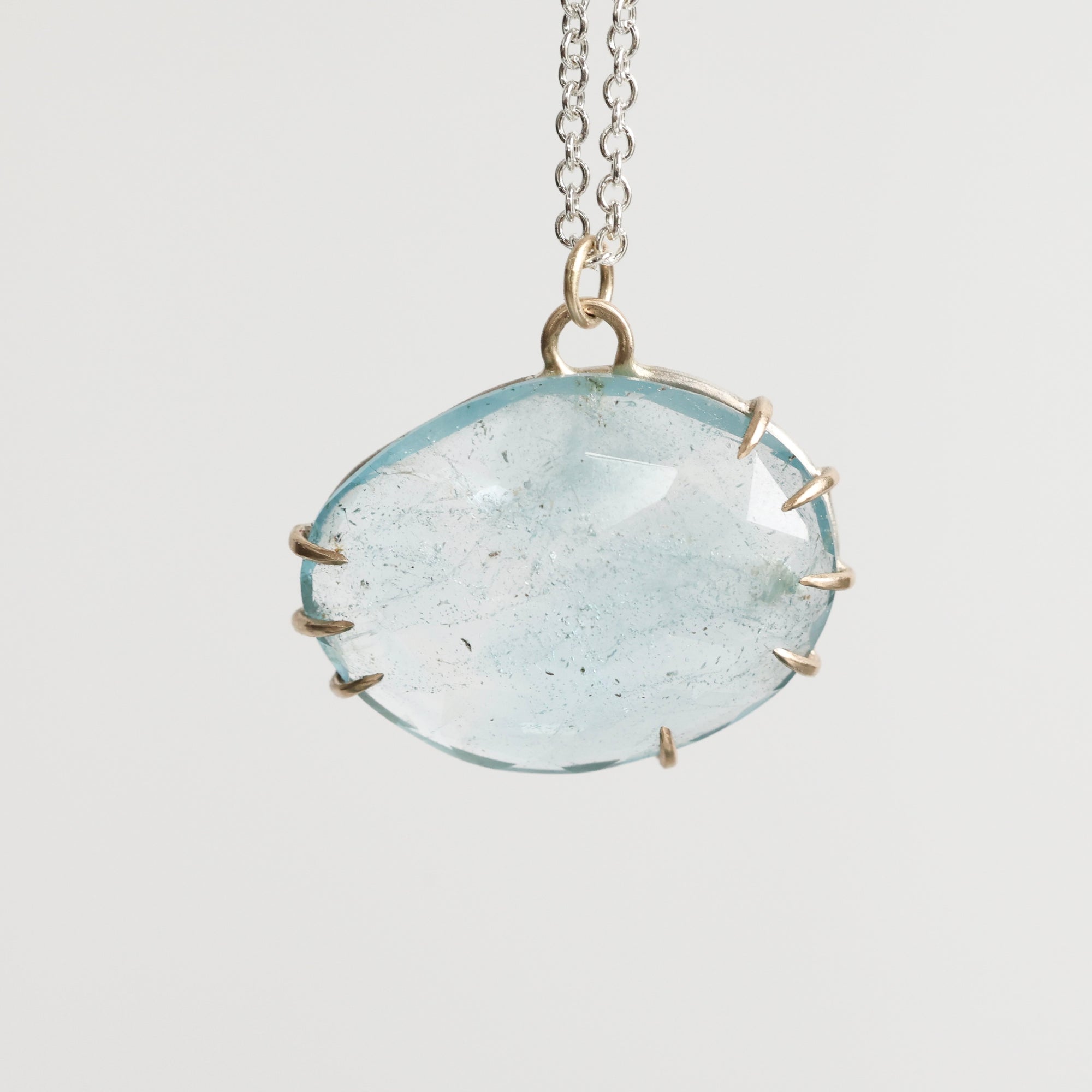 Necklace with a large round clear stone pendant on a light gray background