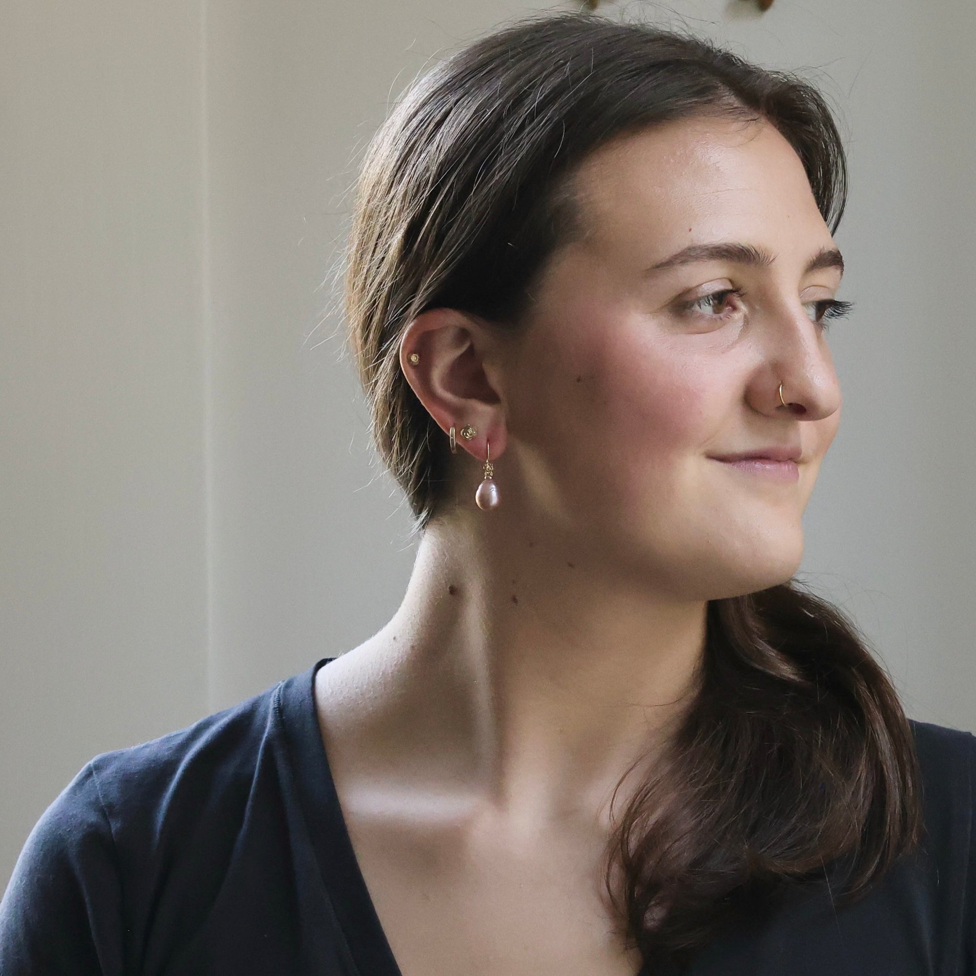 Woman wearing earrings with a neutral background