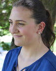 Woman wearing a blue shirt with a blurred green background