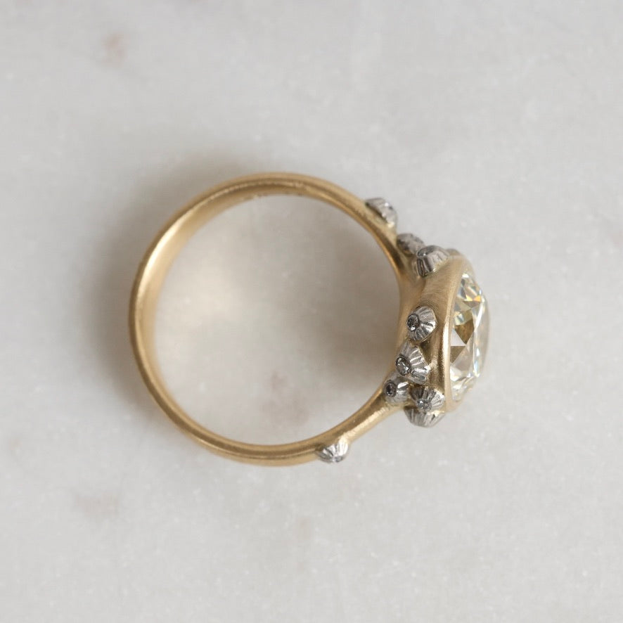 Gold ring with a diamond on a light gray background
