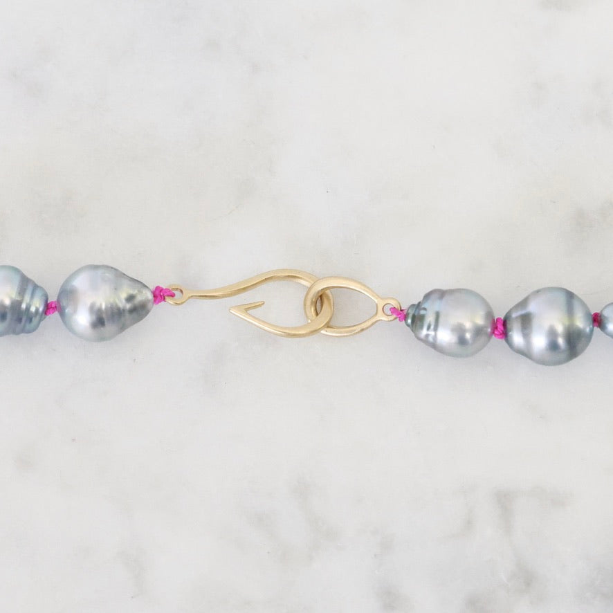 Pearl necklace with a gold clasp on a marble background