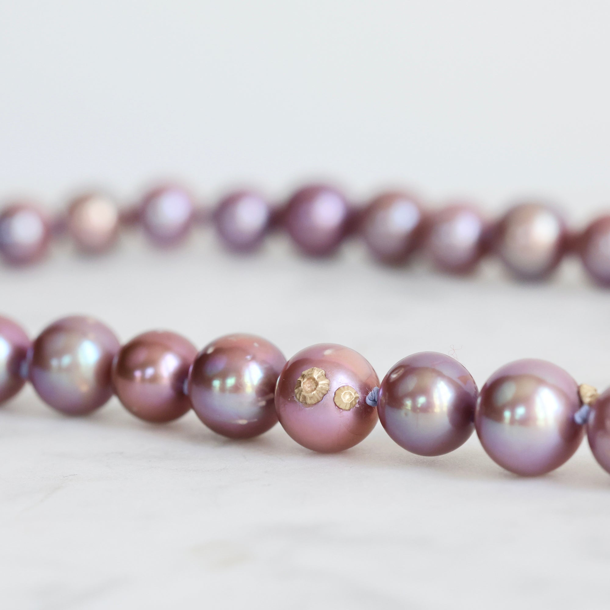 Pink pearl strand with lavender thread and gold barnacles 