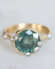 Large green sapphire ring with lots of barnacles. Gold shank