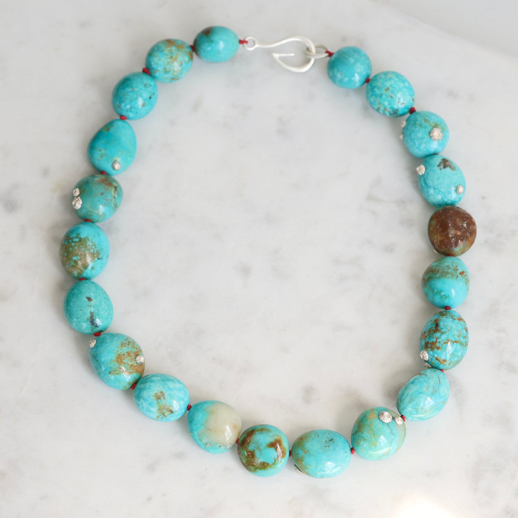 Turquoise Strand with silver barnacles and red thread