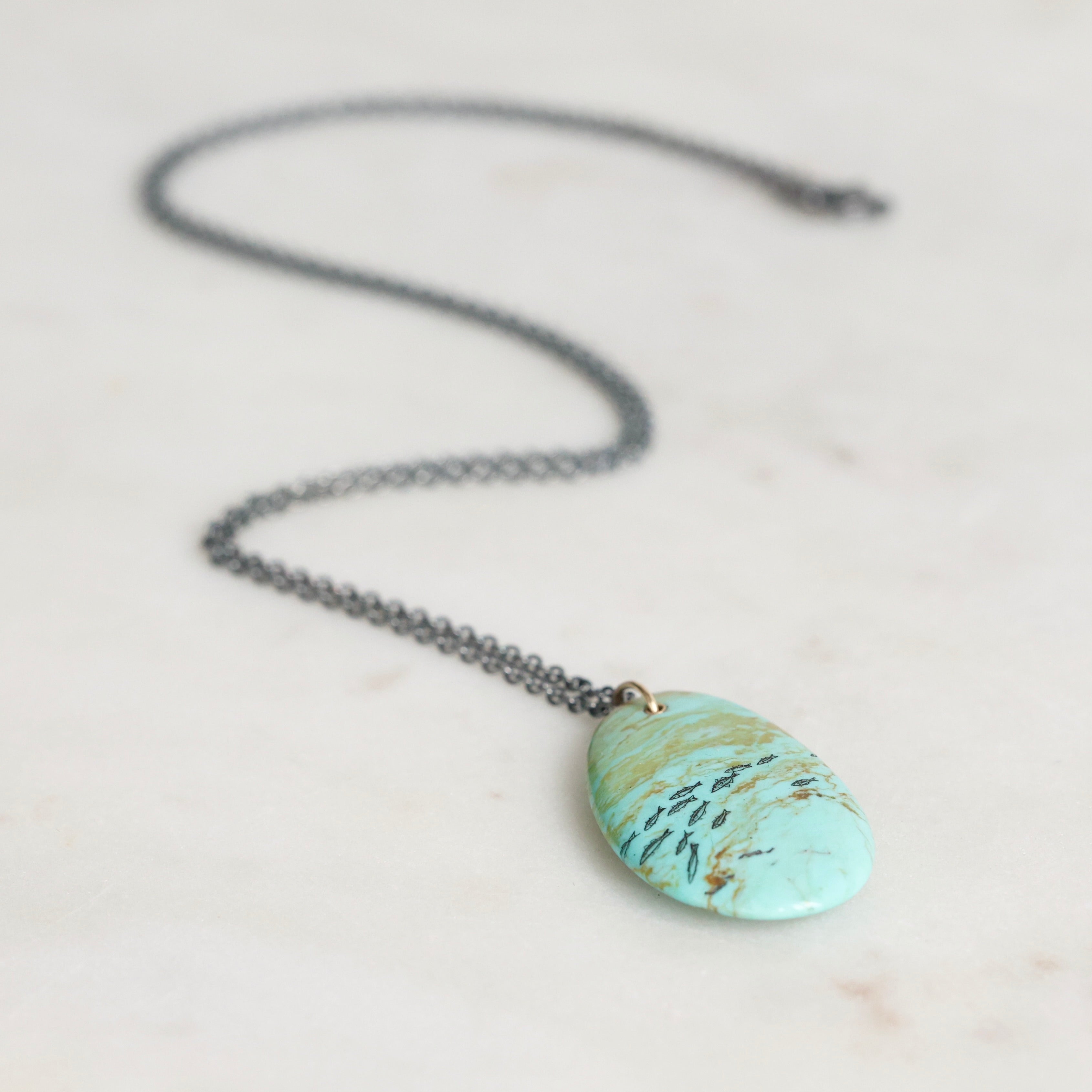 Necklace with a turquoise stone pendant on a light background