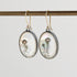 Oval-shaped earrings with jellyfish design on a white background