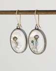 Oval-shaped earrings with jellyfish design on a white background