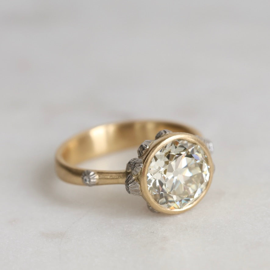 Gold ring with a large diamond on a light gray background