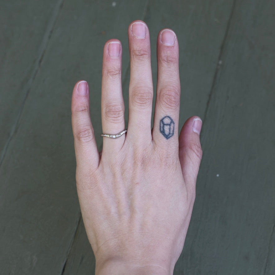 Hand with a ring and tattoo on a dark background