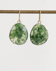 Green stone earrings with gold accents on a white background