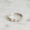 Silver ring with barnacle design on a light gray background