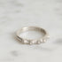 Silver ring with barnacle design on a light gray background