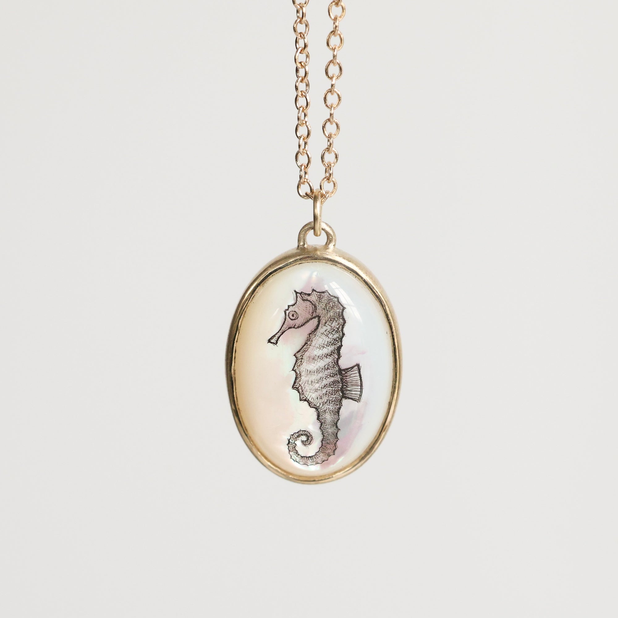 Necklace with a seahorse pendant on a light beige background