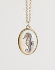 Necklace with a seahorse pendant on a light beige background