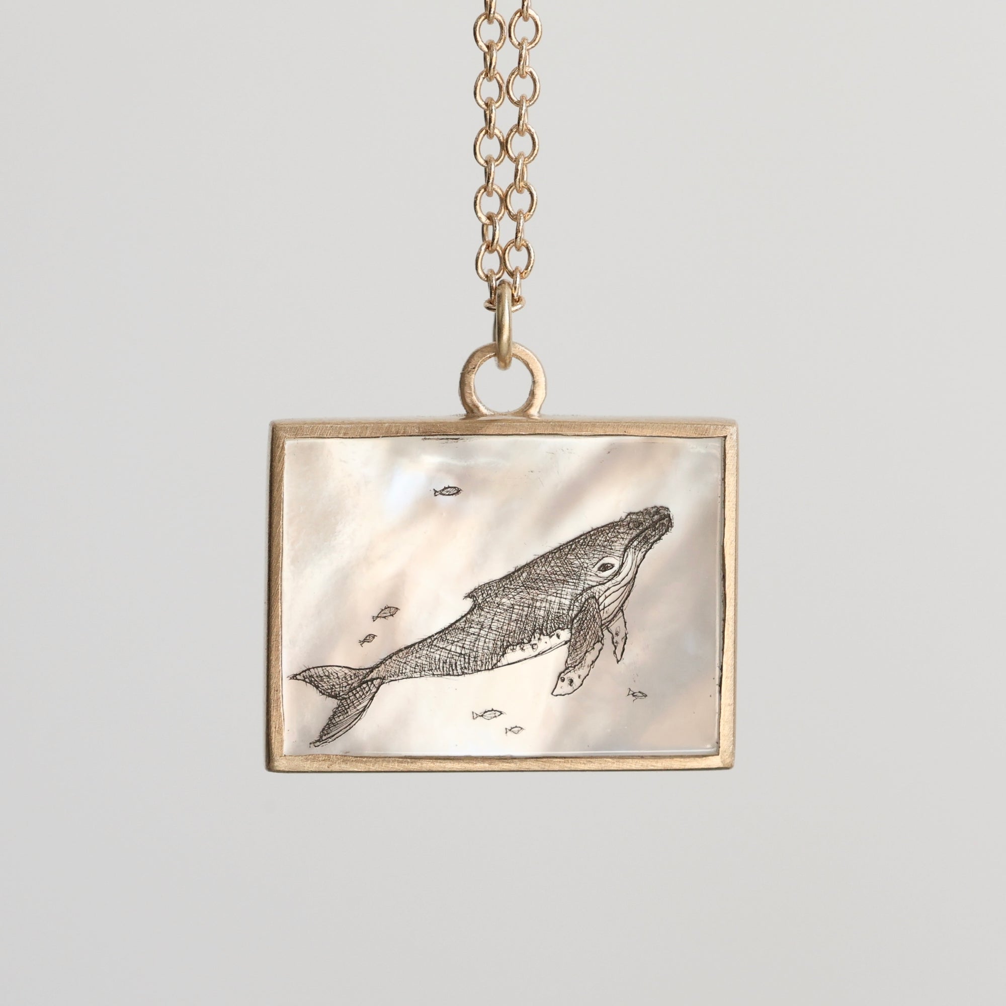 Necklace with a pendant featuring a whale design on a light gray background