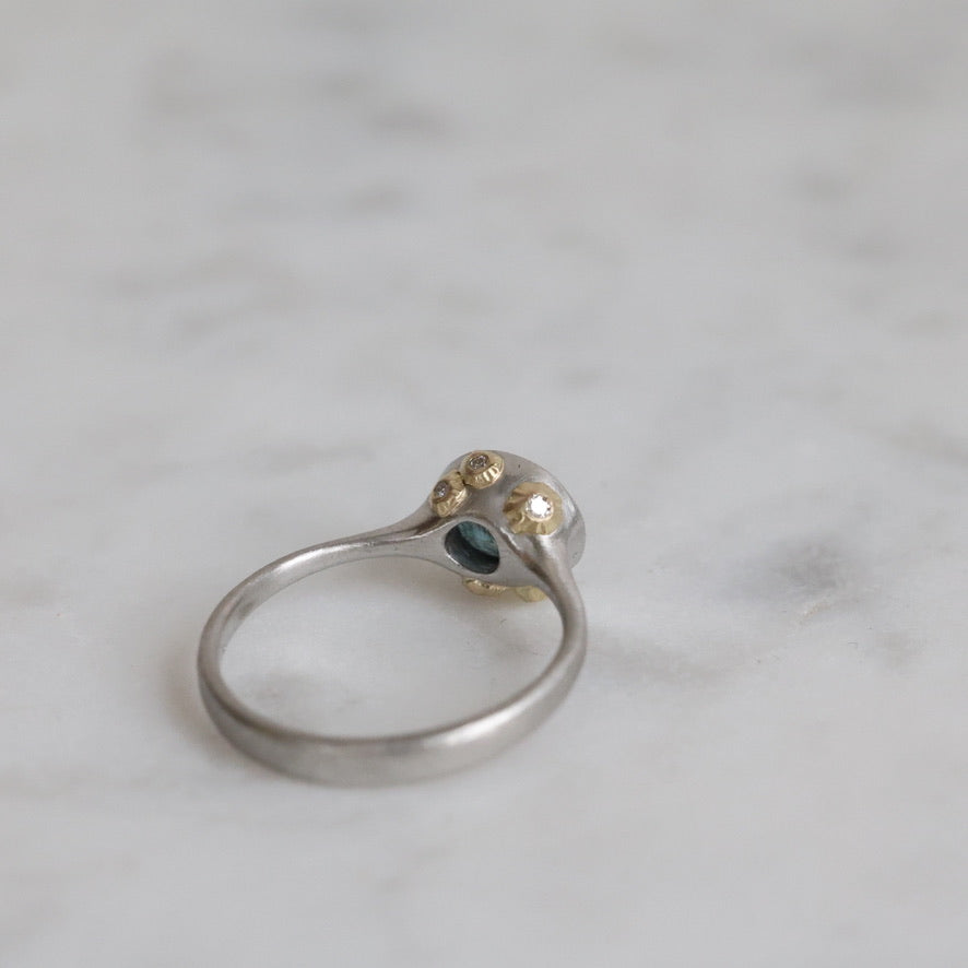 Silver ring with a gemstone on a marble surface