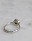 Silver ring with a gemstone on a marble surface