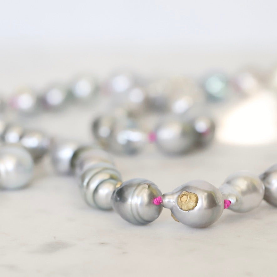 Close-up of a silver pearl necklace on a light background
