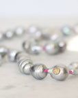 Close-up of a silver pearl necklace on a light background