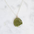 Necklace with a round green pendant on a white background
