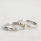 Two silver rings with small embellishments on a light gray background