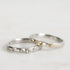 Two silver rings with small embellishments on a light gray background