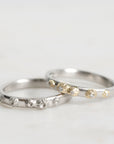 Two silver rings with small embellishments on a light gray background