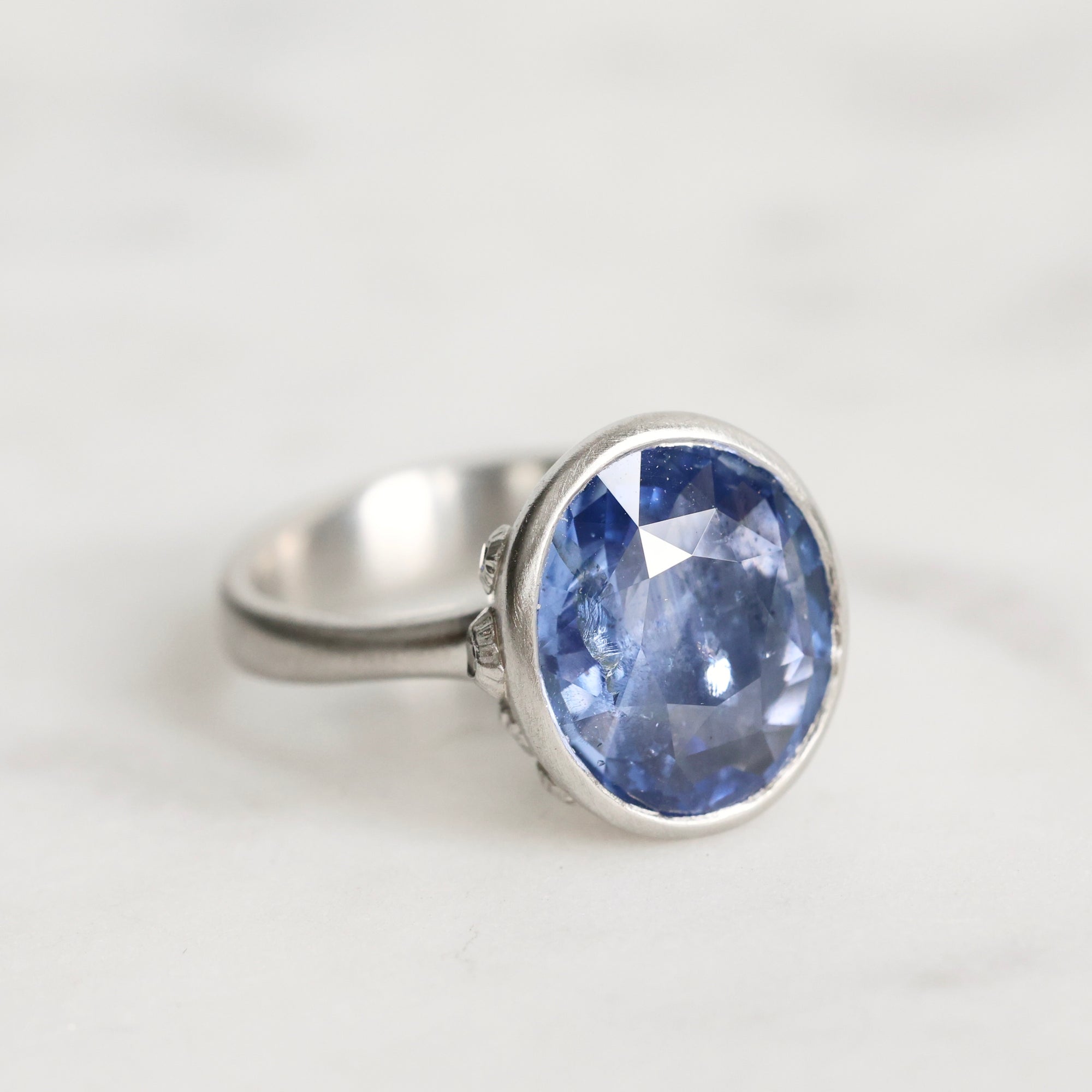 Silver ring with a blue gemstone on a white background